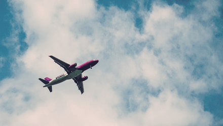 A aeroplane photographed against a blue sky with some clouds