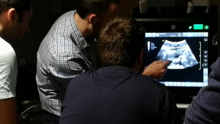 Three men view an ultrasound scan