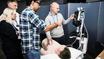 Three men and a woman look at an ultrasound image
