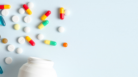 A medication bottle and multi-coloured pills